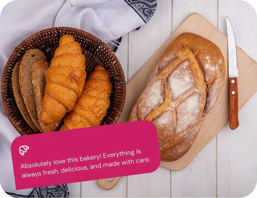 Fresh croissants and a sliced loaf on a cutting board, with a customer quote about the bakery